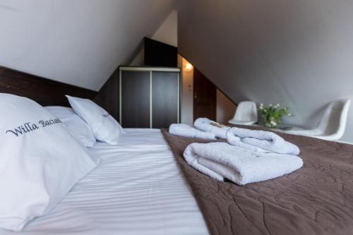 a hotel room with white towels on a bed at Willa Baciarka-basen, sauny i jacuzzi in Kościelisko