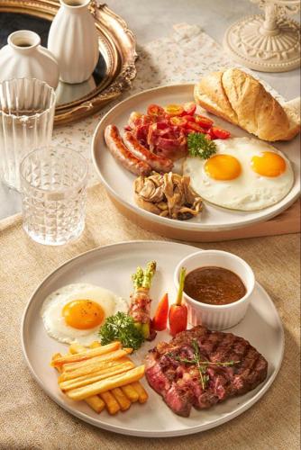 two plates of breakfast food on a table at Lotus Blanc Homestay Village in Battambang