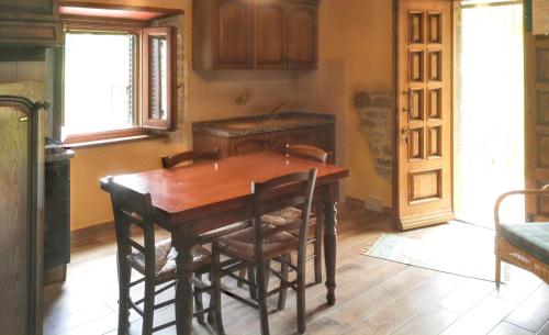 a kitchen with a wooden table and some chairs at Cozy House in Caprese Michelangelo + Pool in Arezzo