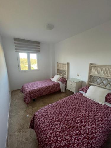 a bedroom with two beds and a window at Apartamento Cala de Mijas in La Cala de Mijas