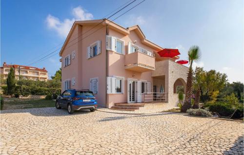 a blue car parked in front of a pink house at Awesome Apartment In Barbat-Rab in Barbat na Rabu