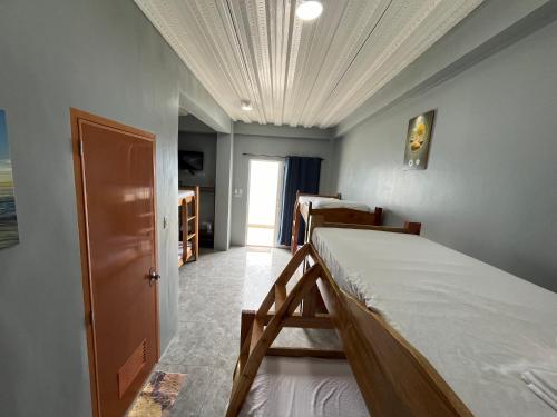 a bedroom with two beds and a ceiling at GOLDEN SUNSET INN in Siquijor