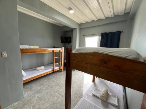 a bedroom with two bunk beds and a window at GOLDEN SUNSET INN in Siquijor