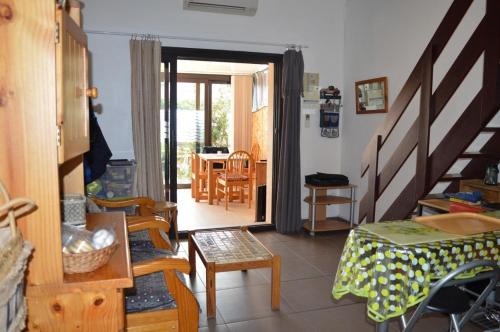 - un salon avec un escalier, une table et des chaises dans l'établissement Maison 2 pièces mezzanine 5 couchages ST CYPRIEN PLAGE SC410-31H, à Saint Cyprien Plage