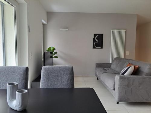 a living room with a couch and a table at Urban Residence by Quokka 360 - Apartments with parking in Lugano in Aldesago