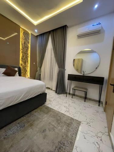 a bedroom with a bed and a mirror and a piano at Marina Vista Apartments in Lekki Phase 1
