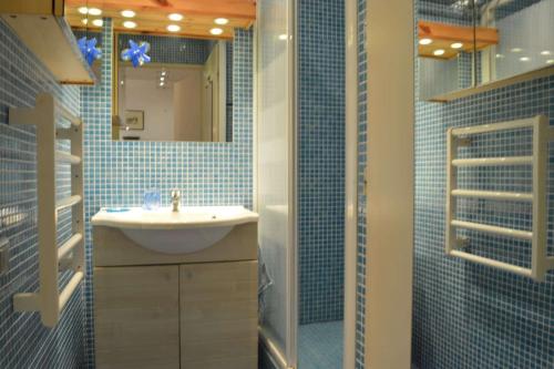 une salle de bain carrelée bleue avec un lavabo et une douche dans l'établissement Appartement 2 pièces 4 personnes SAINT CYPRIEN PLAGE SC090-207, à Saint Cyprien Plage
