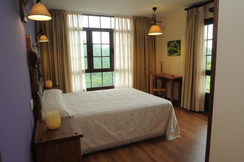 a bedroom with a white bed and a window at El Quesar de Gamoneo in Gamonedo de Cangas