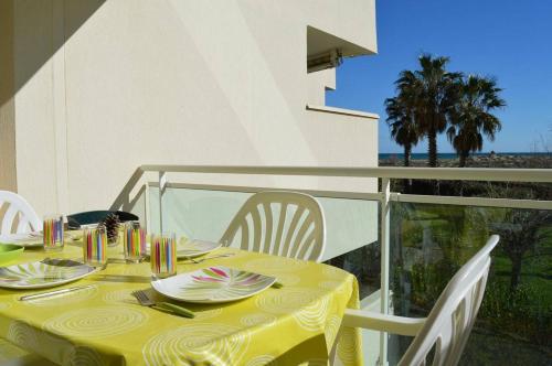 une table avec un chiffon de table jaune sur un balcon dans l'établissement Appartement 2 pièces cabine 6 couchages SAINT CYPRIEN SC050-288A, à Saint Cyprien Plage