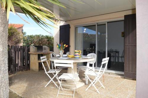 une table blanche et des chaises sur une terrasse dans l'établissement Maison 2 pièces cabine 4 couchages ST CYPRIEN PLAGE SC380-103, à Saint Cyprien Plage