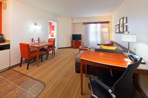 a hotel room with a desk and a living room at Residence Inn Boulder Longmont in Longmont