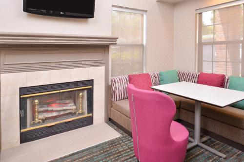 a fireplace in a waiting room with a table and chairs at Residence Inn by Marriott Branson in Branson