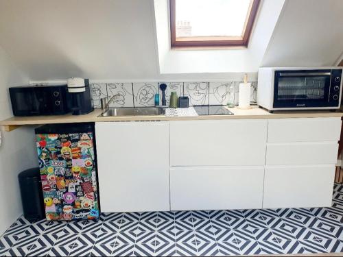 a kitchen with a sink and a microwave at Love Room Charnelle, Chic, Hammam, Clim in Chartres