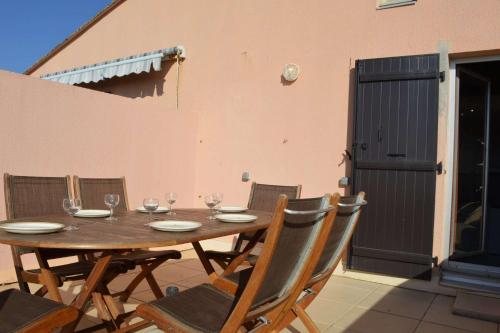 - une table en bois avec des chaises et des verres à vin dans l'établissement Appartement 2 pièces Saint Cyprien 5 personnes sc300-131, à Saint Cyprien Plage