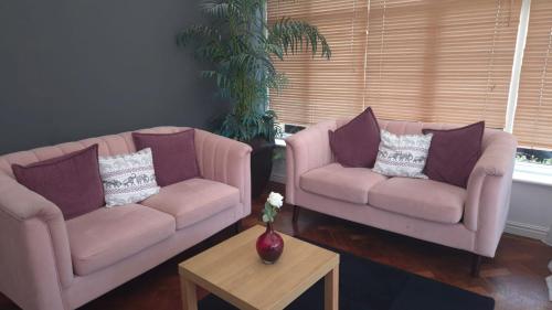 a living room with two chairs and a table at Hunters Meet in Bishops Stortford