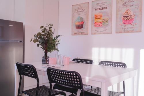 a dining room table with four chairs and a white table at Résidence des Sables in Mably