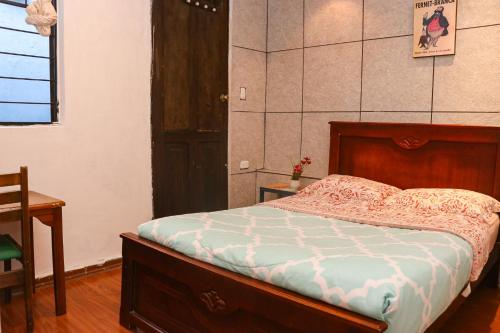 a bedroom with a bed and a table and a window at Blue House Youth Hostel in Quito