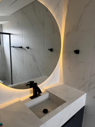 a bathroom with a sink and a mirror at Suíte privada Mariscal in Bombinhas
