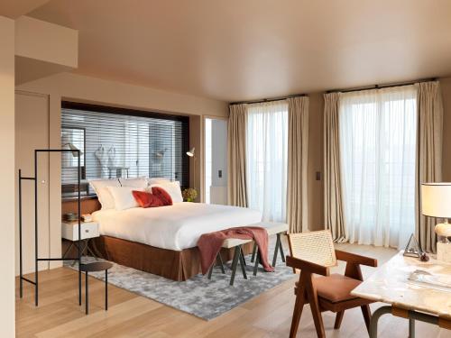 une chambre avec un lit, une table et des chaises dans l'établissement Hotel de Pourtales, à Paris