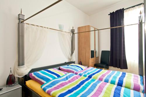 Un dormitorio con una cama con un edredón de rayas de colores. en Apartments Villa Schwan, en Wunstorf