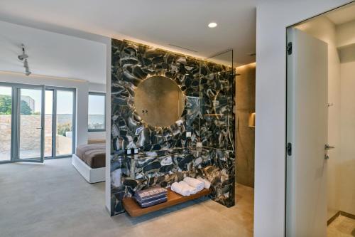 een badkamer met een stenen muur en een spiegel bij Empire Luxury Villas in Santa Maria