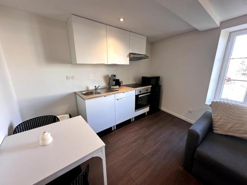 - une petite cuisine avec un évier et une table dans la chambre dans l'établissement Le Contrasté, à Clermont-Ferrand