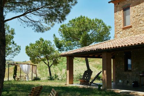 a pavilion on the side of a house with trees at Glamping Le Dune in Cinigiano