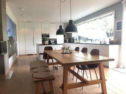a kitchen and dining room with a wooden table and chairs at Beautiful residence, close to great beaches good for surfing in Klepp