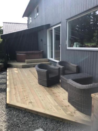 a wooden deck with two couches on a house at Beautiful residence, close to great beaches good for surfing in Klepp