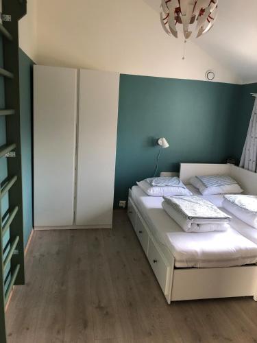 a bedroom with two beds and a blue wall at Beautiful residence, close to great beaches good for surfing in Klepp