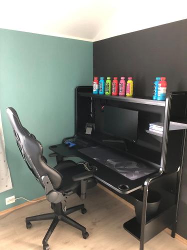 a computer desk with a chair and a monitor at Beautiful residence, close to great beaches good for surfing in Klepp