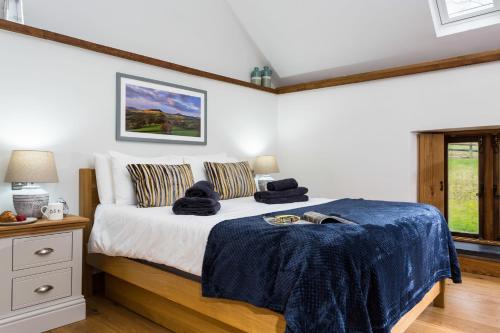 Un dormitorio con una cama con una manta azul encima. en Shepherd's Cottage, en Usk