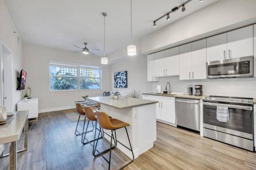 a kitchen with white cabinets and a table and chairs at Trendy One Bedroom Getaway Steps from Biscayne in Miami