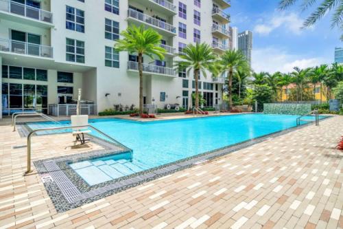 a swimming pool in front of a building at Trendy One Bedroom Getaway Steps from Biscayne in Miami