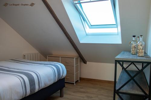 a bedroom with a bed and a skylight at Appartement dans le bourg de Notre Dame du Guildo - Saint-Cast in Saint-Cast-le-Guildo