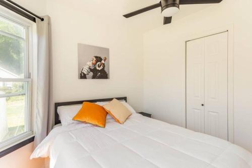 a bedroom with a white bed with orange pillows at Charming Duplex4min To Mohegan18min To Foxwoods in Norwich