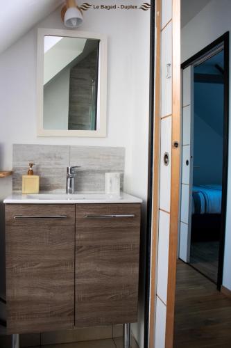 une salle de bain avec un lavabo et un miroir dans l'établissement Appartement dans le bourg de Notre Dame du Guildo - Saint-Cast, à Saint-Cast-le-Guildo