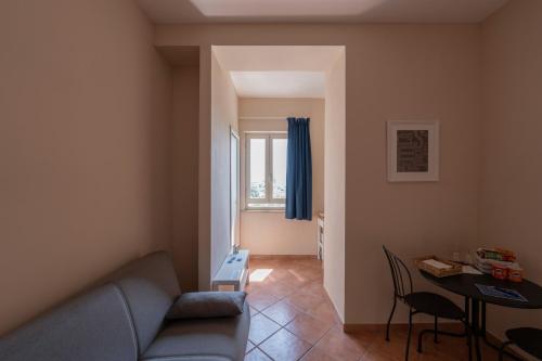 a living room with a blue couch and a table at Artis Mare in Pozzuoli