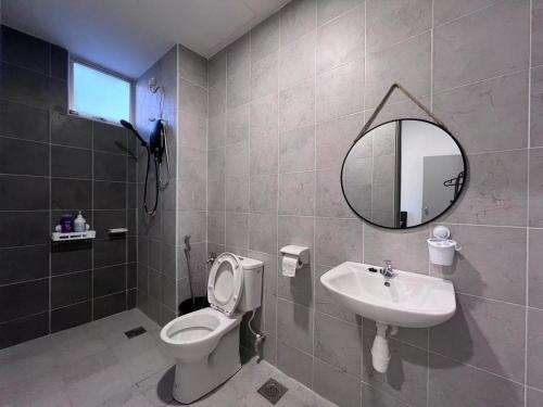 a bathroom with a toilet and a sink and a mirror at BW White Falim Ipoh in Ipoh
