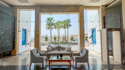a living room with a couch and two chairs and a table at Sharm Club Beach Resort in Sharm El Sheikh