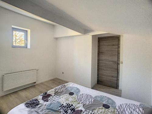 a bedroom with a bed and a window and a door at Rue Isaac 15 D in Charleroi