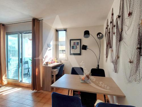Cette chambre dispose d'une table, de chaises et d'un bureau. dans l'établissement RDC avec piscine, climatisation et garage, à Sète