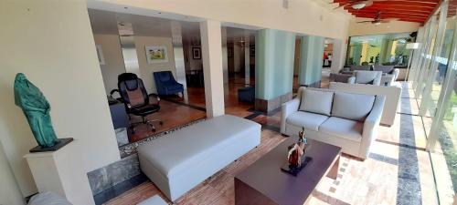 a living room with a white couch and chairs at Holiday Inn Cuernavaca by IHG in Cuernavaca
