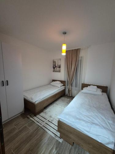 a room with two beds and a pendant light at Bjance Lux Prijepolje in Prijepolje