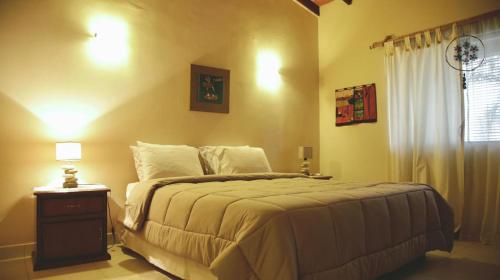 a bedroom with a bed and a table with a lamp at Mandala Apartments 2 ambientes in Luque