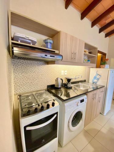 a kitchen with a stove and a washing machine at Mandala Apartments 2 ambientes in Luque