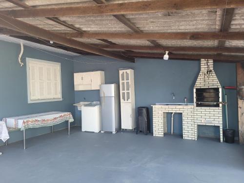 a room with a kitchen with a stove and refrigerator at Isamara in Tramandaí