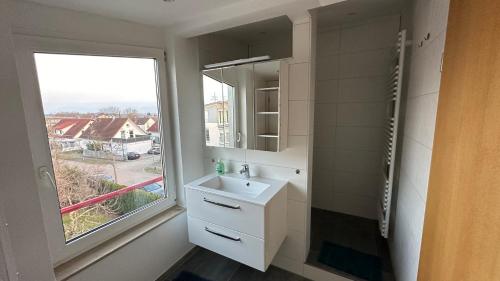 a white bathroom with a sink and a window at Ostalb Inn - Haus Emely in Schwäbisch Gmünd