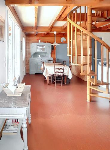 un salon avec une table et un escalier dans l'établissement Maison accueillante à Vielle-Saint-Girons avec jardin et cheminée, à Vielle-Saint-Girons