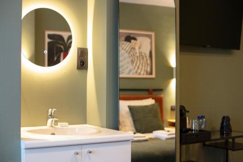 a bathroom with a sink and a mirror and a bed at Gillis Eight Guest Rooms by Romy&Travis in Bruges